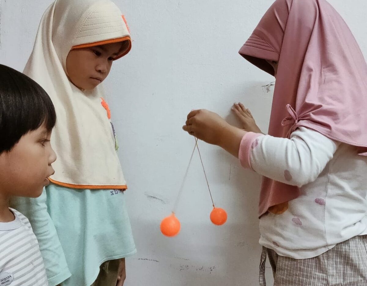 Lato Lato. Anak-anak sedang fokus memainkan lato-lato. Foto: Suhardi Makmur/Mas Andre Hariyanto (SUARA UTAMA)