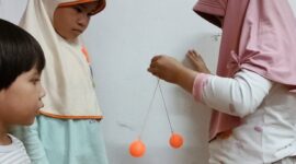 Lato Lato. Anak-anak sedang fokus memainkan lato-lato. Foto: Suhardi Makmur/Mas Andre Hariyanto (SUARA UTAMA)