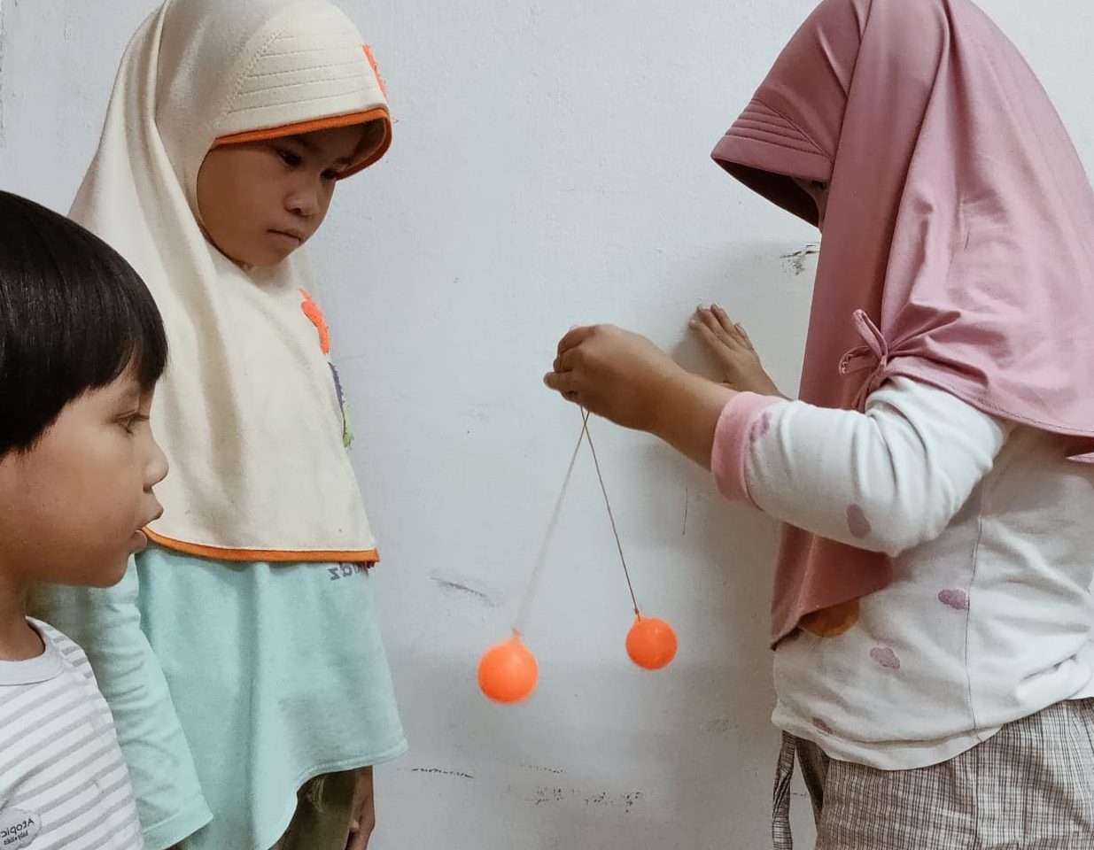 Lato Lato. Anak-anak sedang fokus memainkan lato-lato. Foto: Suhardi Makmur/Mas Andre Hariyanto (SUARA UTAMA)