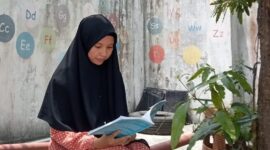 Foto Penulis Kurikulum Falsafah Pendidikan Islam Asmaul Husna sedang membaca Buku