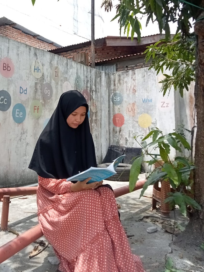 Foto Penulis Kurikulum Falsafah Pendidikan Islam Asmaul Husna sedang membaca Buku