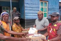 Penyerahan bantuan bama oleh Pimpinan Gereja Katolik Dekenat Moni-Puncak, P.Yance Yogi, Pr. Kepada Umat dari kampung Jomba,Senin,(27/11) di halaman rumah Pastoran Bilogai/foto.Kalis