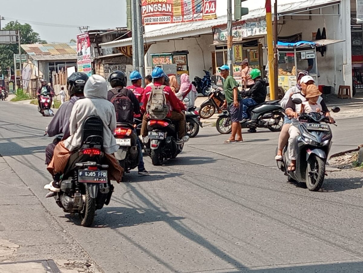 Foto : Haris supeltas sedang mengatur lalin pertigaan jalan Bojonggede dan jalan Tonjong  (Agus Budiana/Suara Utama)