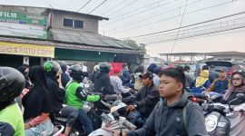 Foto : Pengguna roda 2 saat melintas pada lintasan kereta commuterline jalan Gaperi Bojonggede (Agus Budiana/Suara Utama)