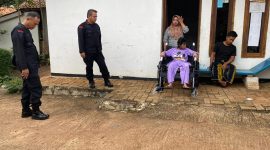 Anggota resimen 3 pasukan pelopor korps Brimob polri sedang memberikan bantuan sosial berupa satu kursi roda pada salah satu warga RT 02/RW 04 Cikeas, Bogor. ( Itam Mustopa/Suara Utama)
