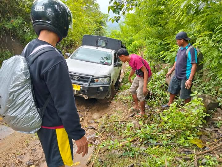 Foto : Warga sedang berusaha membantu mobil yang melintasi jalan Kelawis Mungkin, dusun Kopo  desa Mungkin Kecamatan Orong Telu Sumbawa NTB. (Mulyadi /Suara Utama)