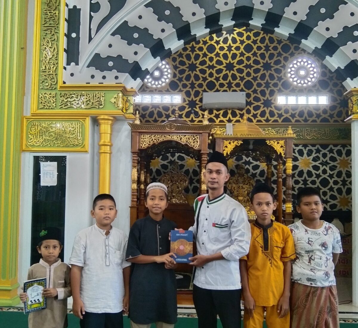 Senyum bahagia anak-anak saat menerima bantuan Iqro dan Al-Qur’an dari program Sarjana Bina Desa Muara Enim