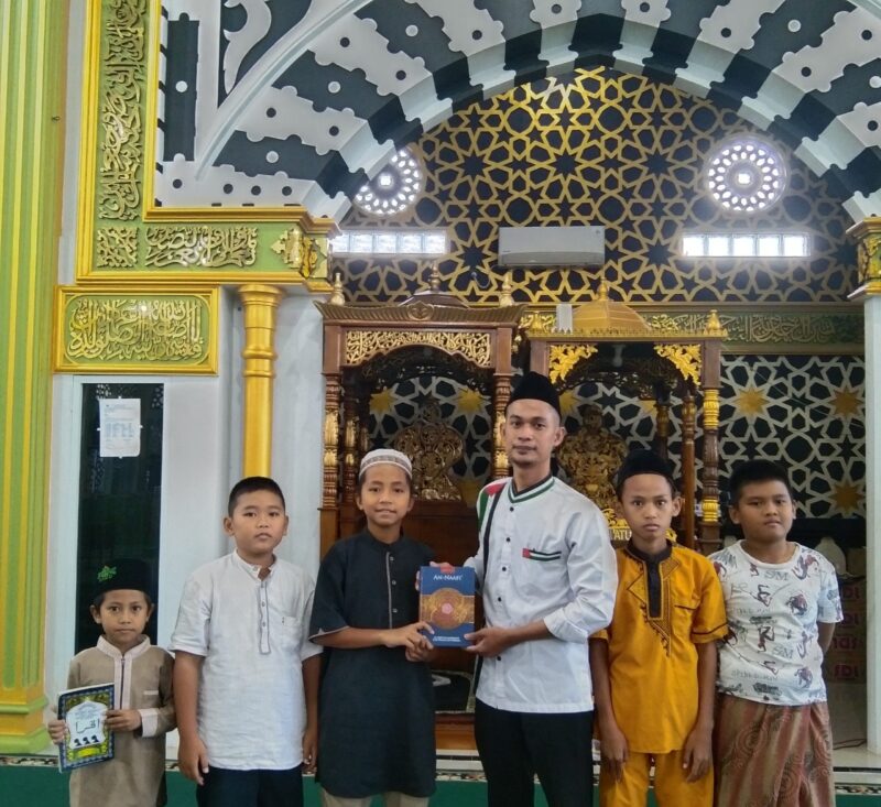 Senyum bahagia anak-anak saat menerima bantuan Iqro dan Al-Qur’an dari program Sarjana Bina Desa Muara Enim