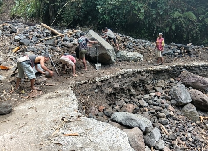 Warga Desa Nua Bolo membersihkan saluran air yang rusak akibat banjir bandang di Mauponggo.