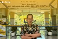 Yulianto Kiswocahyono, SE., SH., BKP, Konsultan Pajak Senior dan Ketua Komite Tetap Bidang Fiskal dan Moneter KADIN Jawa Timur, di depan kantor DJP dengan banner 