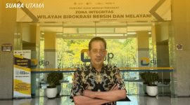 Yulianto Kiswocahyono, SE., SH., BKP, Konsultan Pajak Senior dan Ketua Komite Tetap Bidang Fiskal dan Moneter KADIN Jawa Timur, di depan kantor DJP dengan banner 