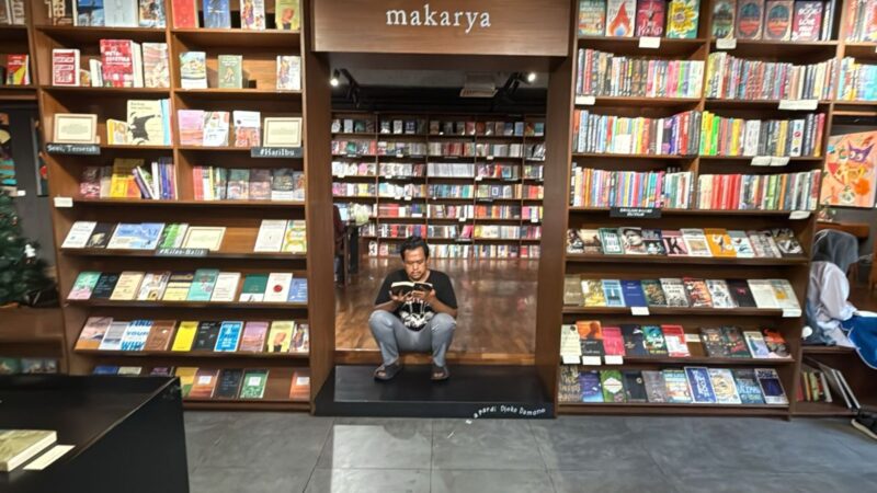 Reyhan Alarico Stewart, mahasiswa Sosiologi UINSA, membaca buku di ruang literasi Makarya sebagai wujud pemanfaatan masa liburan untuk memperkuat budaya literasi dan refleksi diri.